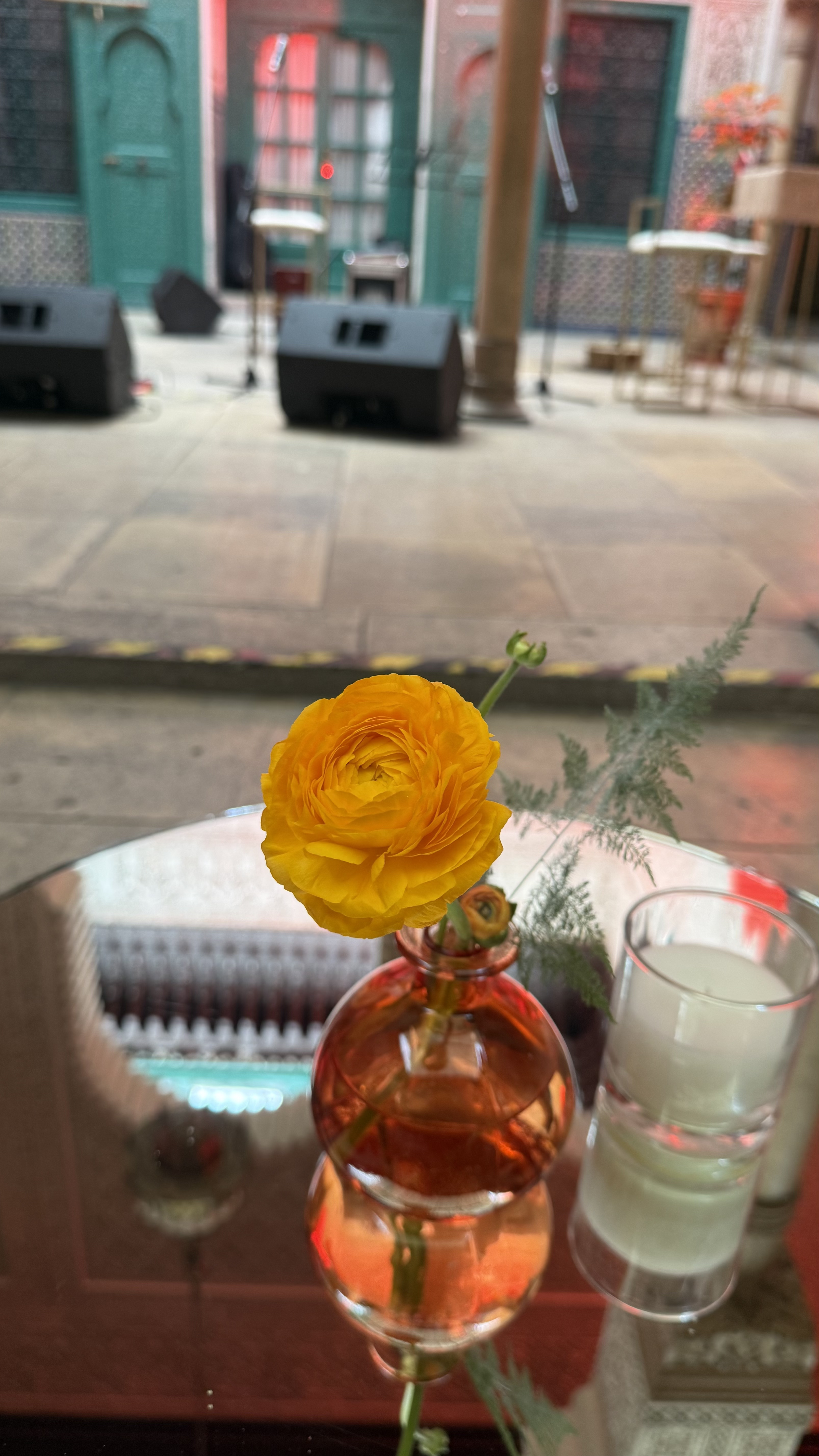Corporate event for Orange at the Mahkama du Pacha in Habous, Casablanca — orange linens, terracotta vases with ranunculus and gerbera, candlelight and carved Moorish arches, produced by SBAI Events Production