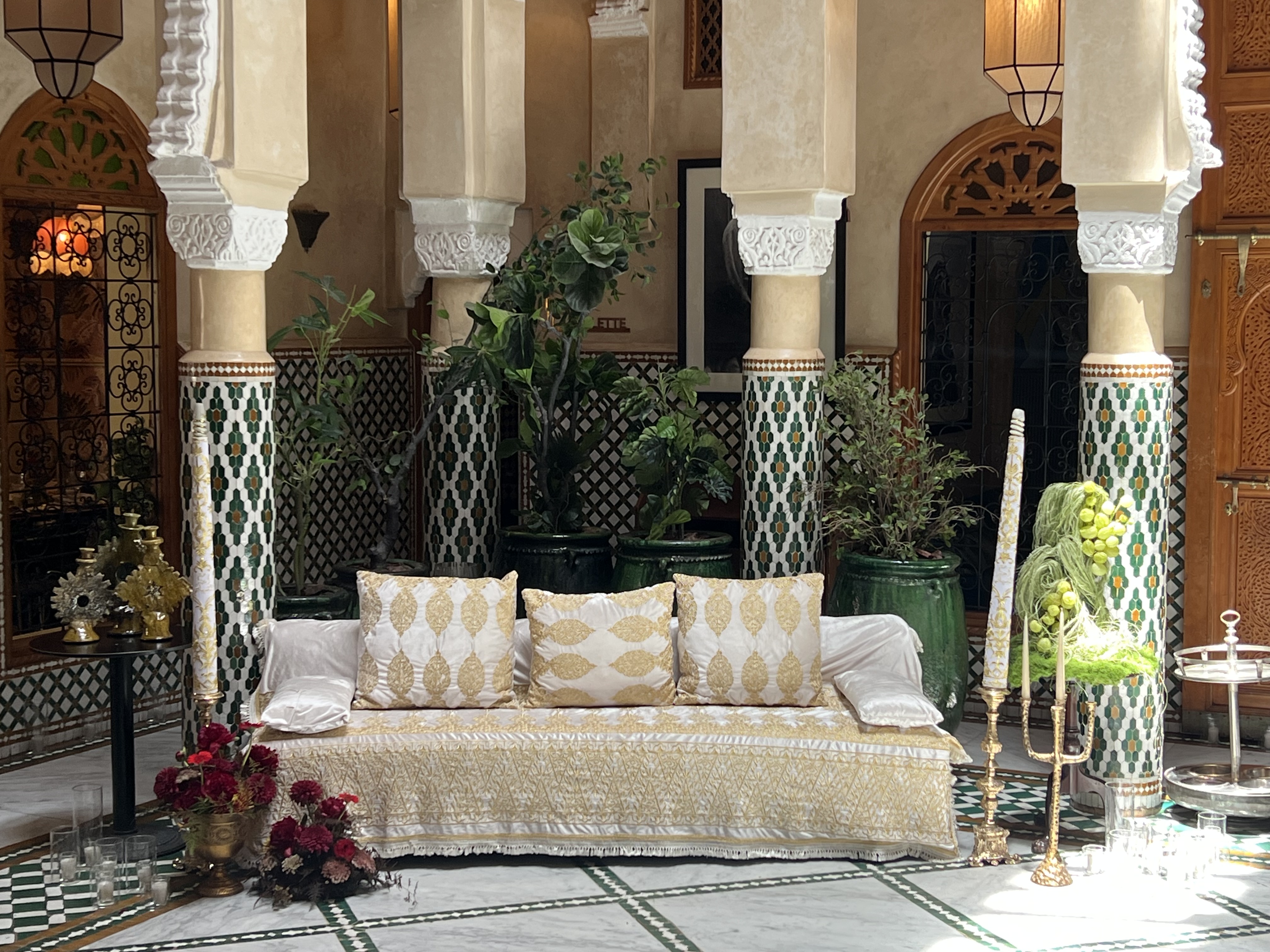 Wedding at Dar Dada Casablanca — gilded welcome mirror, crimson and burgundy floral centerpieces, zellige tables and candlelight, produced by SBAI Events Production