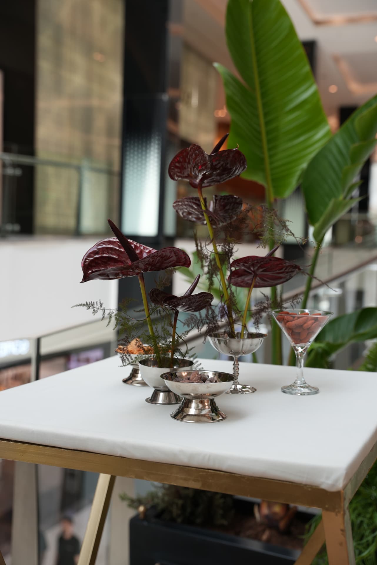 Kara.S boutique opening at Morocco Mall — burgundy anthurium and pink cymbidium installations, silver coupes and brass tables, produced by SBAI Events Production