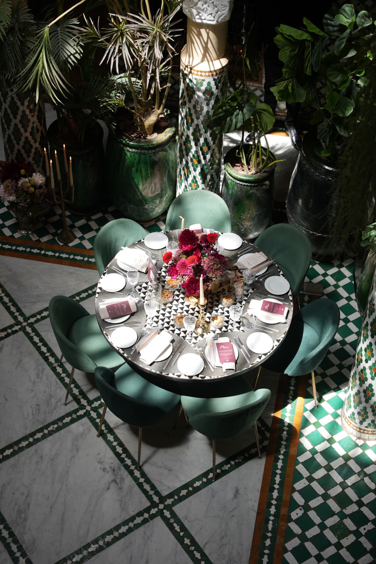Wedding at Dar Dada Casablanca — gilded welcome mirror, crimson and burgundy floral centerpieces, zellige tables and candlelight, produced by SBAI Events Production