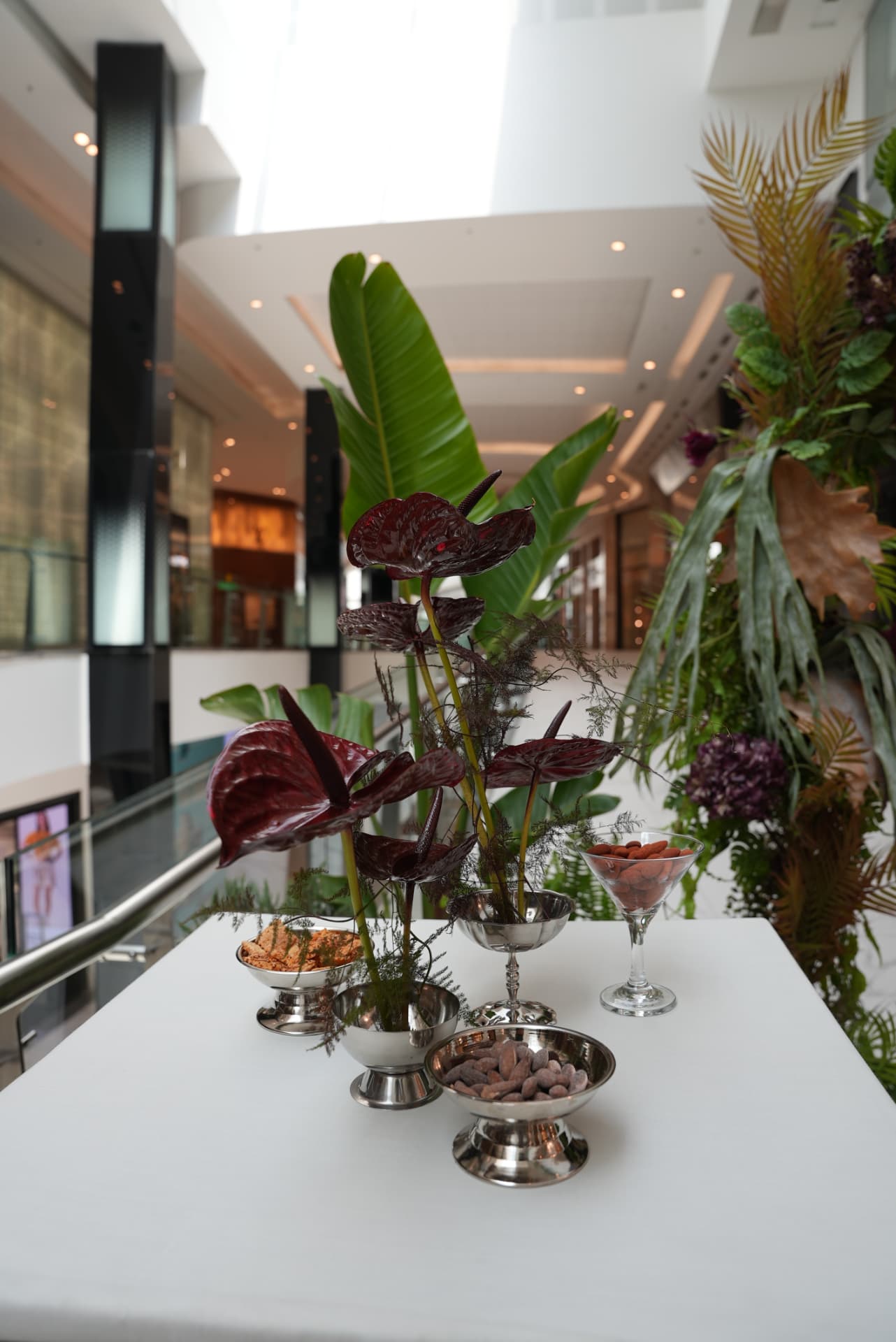 Kara.S boutique opening at Morocco Mall — burgundy anthurium and pink cymbidium installations, silver coupes and brass tables, produced by SBAI Events Production