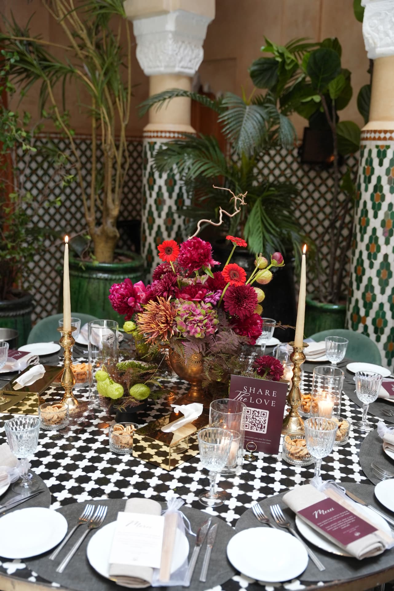 Wedding at Dar Dada Casablanca — gilded welcome mirror, crimson and burgundy floral centerpieces, zellige tables and candlelight, produced by SBAI Events Production
