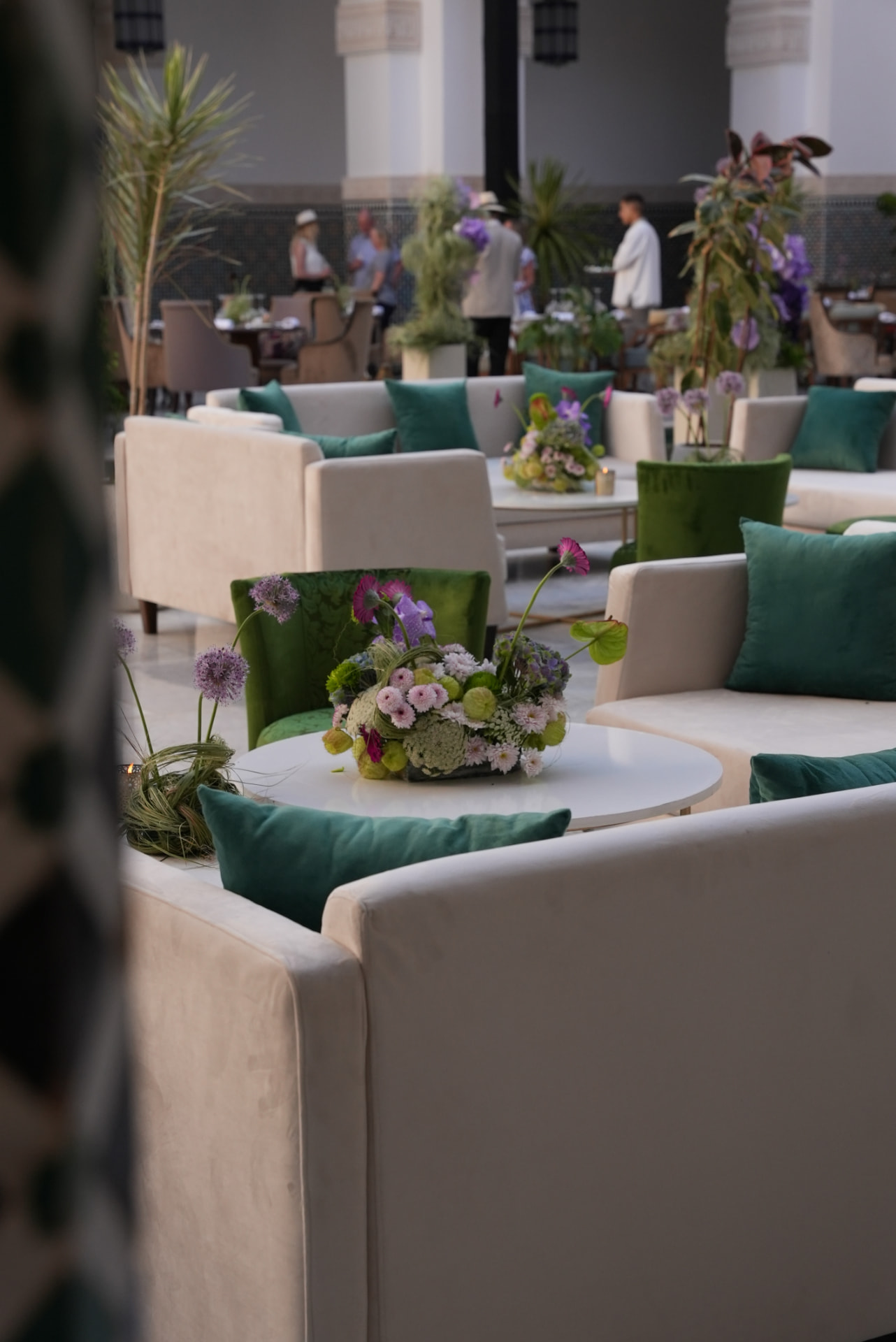 Gala Dinner Vegetal Garden at the patio of the Oberoi Marrakech — purple vanda orchids and anthuriums on white plinths above the emerald reflecting pool, ivory lounges and brass lanterns, produced by SBAI Events Production