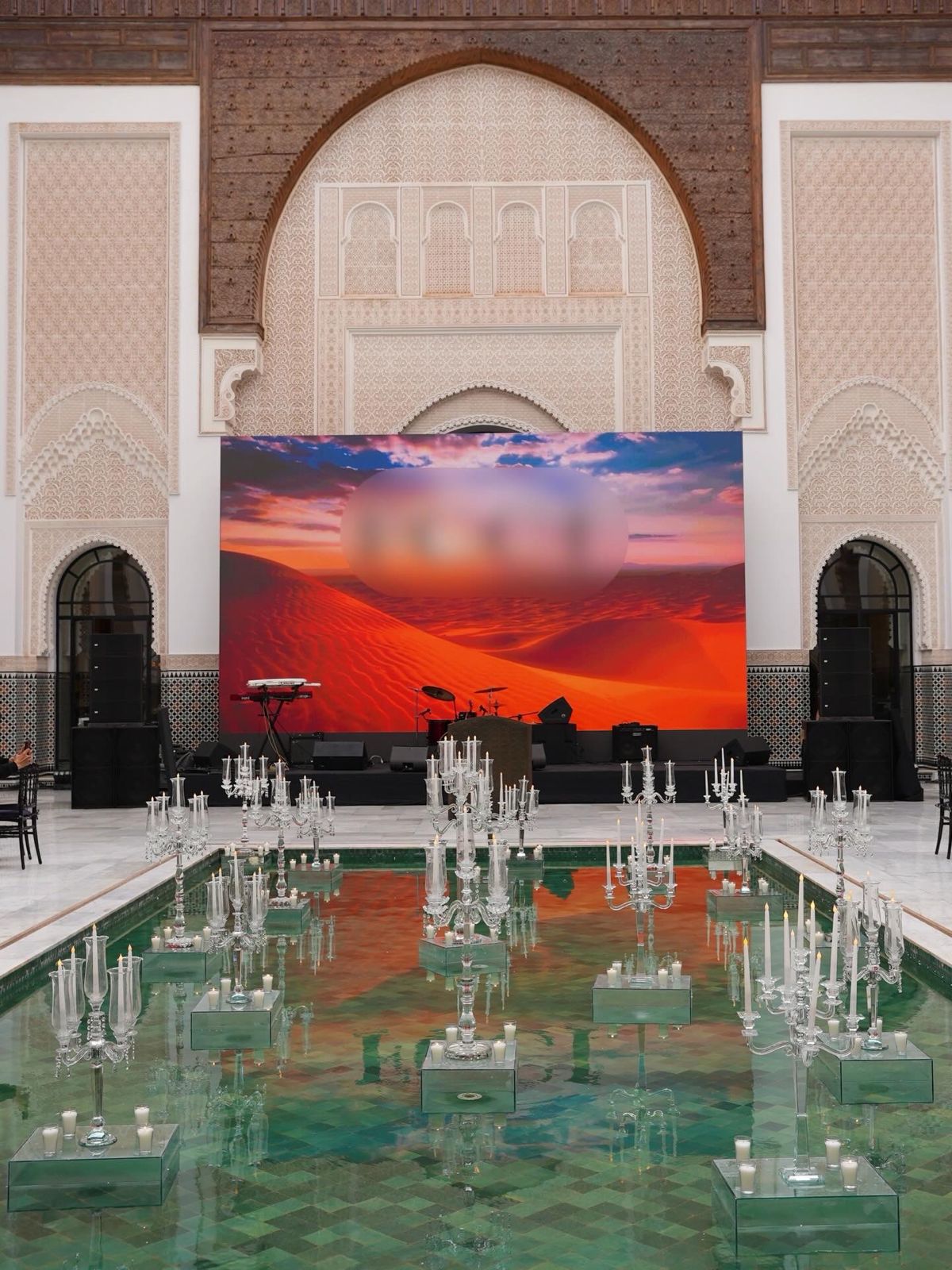 Symmetric front view of a reflecting pool lined with crystal candelabras inside a Marrakech palace courtyard, produced by SBAI Events Production