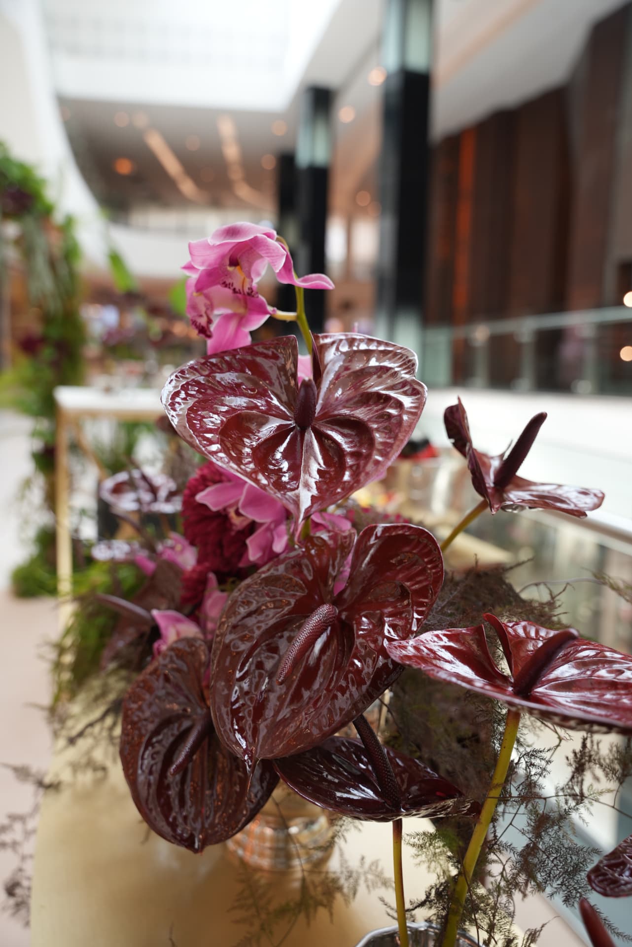 Kara.S boutique opening at Morocco Mall — burgundy anthurium and pink cymbidium installations, silver coupes and brass tables, produced by SBAI Events Production