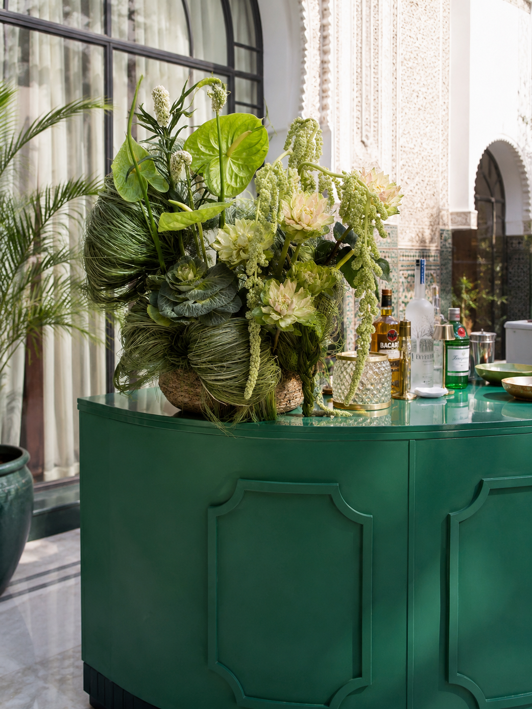 Lush green floral bar installation with tropical foliage and premium spirits at a luxury wedding reception, styled by SBAI Events Production