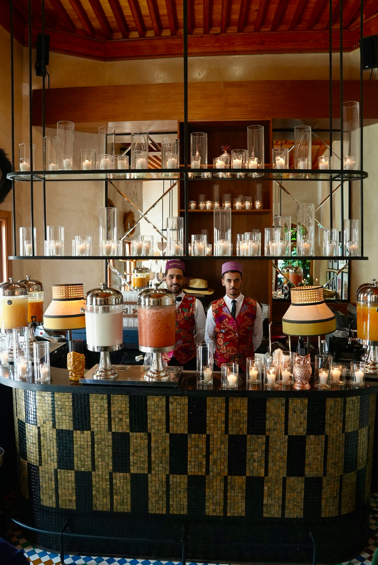 Wedding at Dar Dada Casablanca — gilded welcome mirror, crimson and burgundy floral centerpieces, zellige tables and candlelight, produced by SBAI Events Production