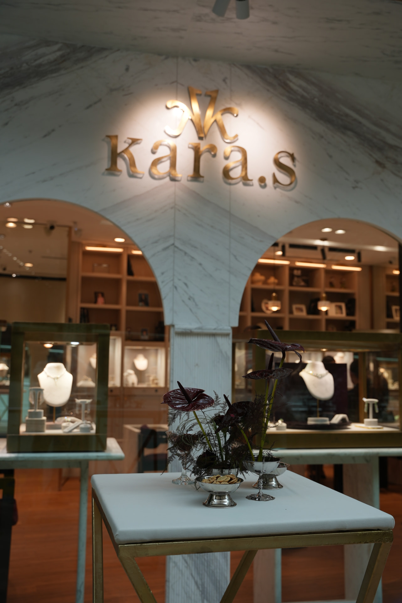 Kara.S boutique opening at Morocco Mall — burgundy anthurium and pink cymbidium installations, silver coupes and brass tables, produced by SBAI Events Production