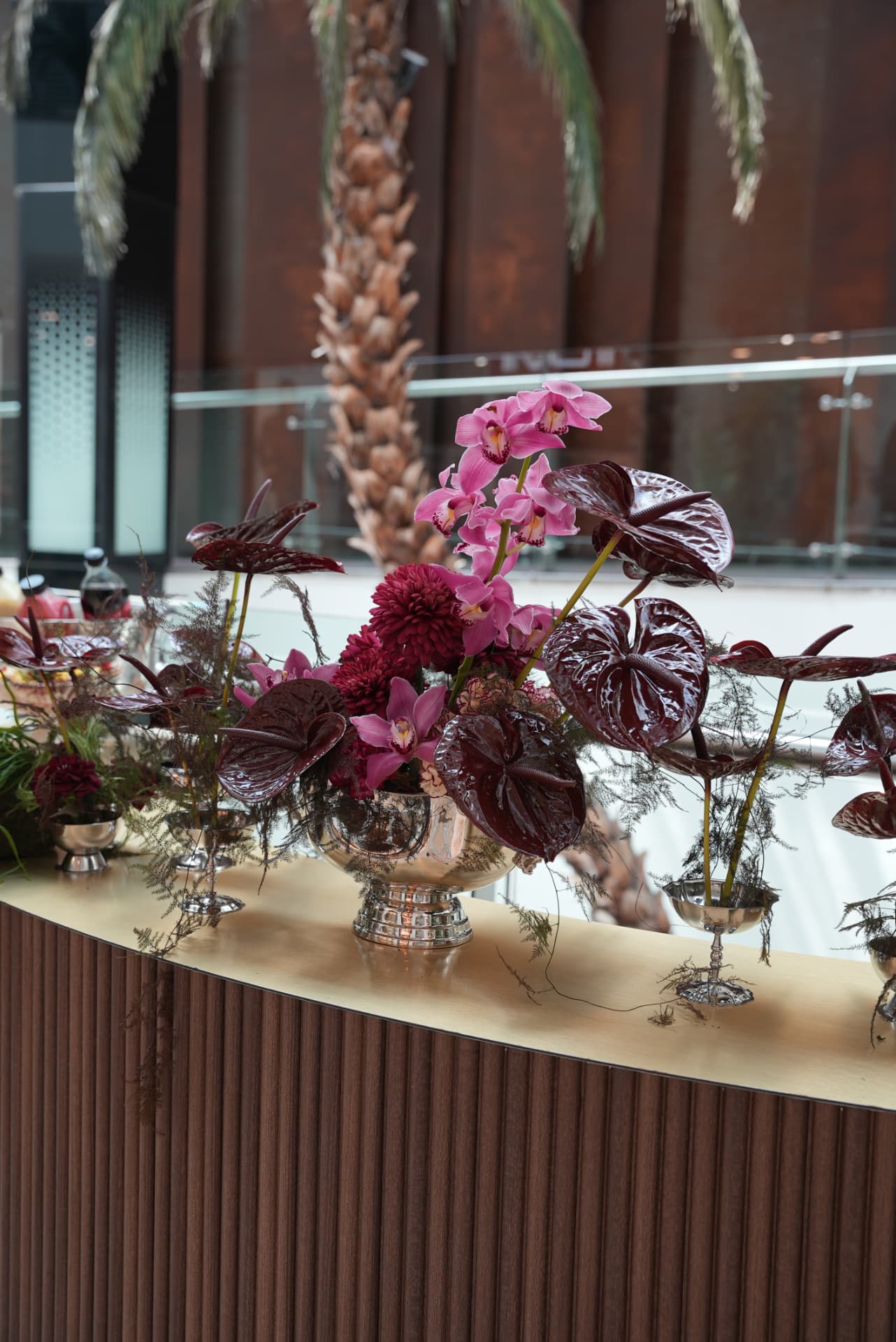 Kara.S boutique opening at Morocco Mall — burgundy anthurium and pink cymbidium installations, silver coupes and brass tables, produced by SBAI Events Production